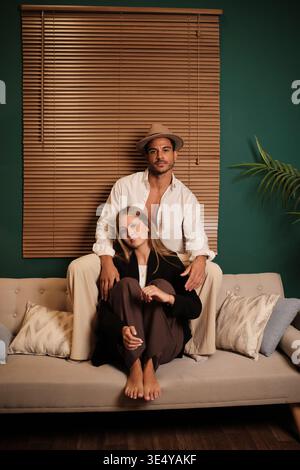 Stilvolles Paar, das sich auf dem Sofa entspannt und intim fühlt Stockfoto