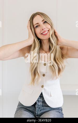 Lächelnde junge Frau mit langen blonden Haaren Stockfoto