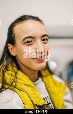 Frau mit gelber Weste, die mit Septumring lächelt Stockfoto