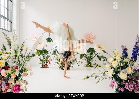 Tänzerin mit Handstand im Blumenstudio Stockfoto