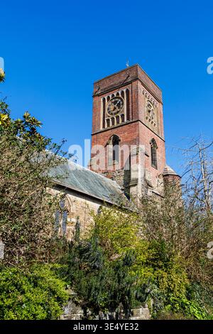Blick auf die Kirche St. Mary the Virgin in Petworth, einer kleinen Stadt in West Sussex, England mit ihrem quadratischen roten Backsteinturm Stockfoto