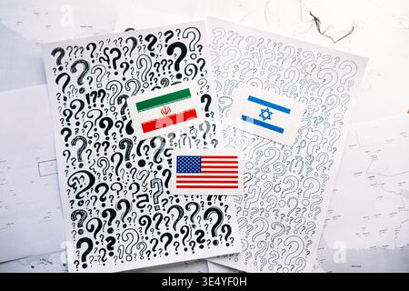 Flaggen des IRAN, ISRAELS und der USA liegen auf Papieren mit Fragezeichen über geografischen Karten. USA Israel Iran, Nahost-Krise, regionales Konfliktrisiko Stockfoto