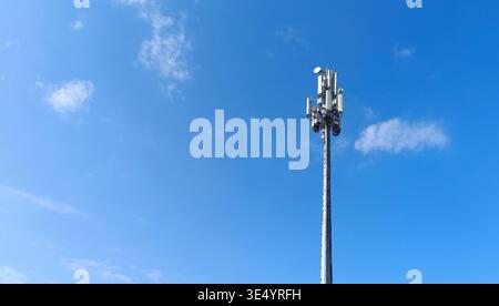 Ein moderner Telekommunikationszellen-Turm (BTS) mit Antennen und Sendern vor klarem blauem Himmel. Konzept von 5G, Mobilfunknetz, Signalabdeckung, A Stockfoto