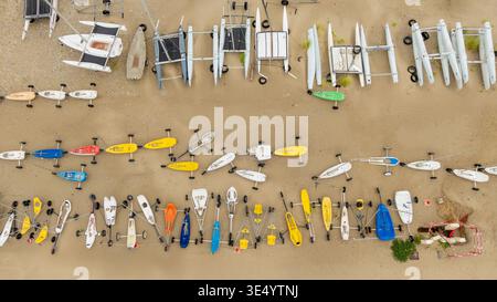 Blick aus der Vogelperspektive auf den Strand mit farbenfrohen Booten und Katamaranen auf dem goldenen Sand, Fort-Mahon-Plage, Hauts-de-France, Frankreich. Stockfoto