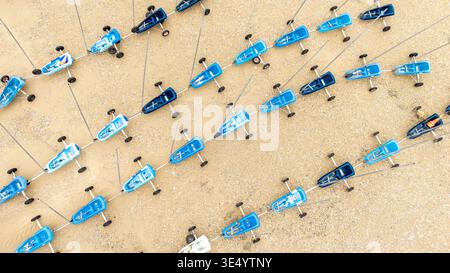 Luftaufnahme einer Flotte identischer blauer und weißer Segelwagen am Sandstrand Fort-Mahon-Plage, Hauts-de-France, Frankreich. Stockfoto