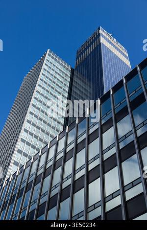 Flacher Blick auf zwei moderne Glasbürotürme vor klarem blauem Himmel, mit reflektierenden Fassaden an den Vorhängen, Stadtzentrum von Manchester. Stockfoto