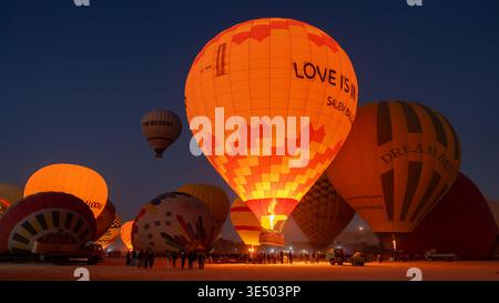 Dichte Gruppe von lebhaften Heißluftballons, die sich auf den Start in Luxor, Ägypten, vorbereiten Stockfoto