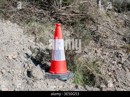 Hellorangefarbener Verkehrskegel an der Straßenseite des Baubereichs Sicherheitswarnausrüstung im Außenbereich Stockfoto
