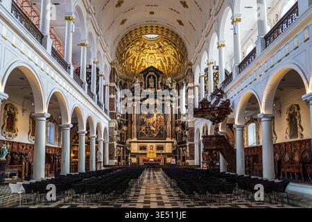 Majestätisches barockes Interieur mit dem Hochaltar mit dem Gemälde der Kreuzerhöhung. Bemerkenswerte weiße korinthische Säulen, ein fein geschnitzter Eichenpul Stockfoto