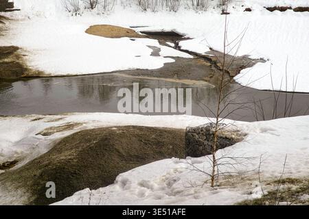 Schmelzender Schnee und schmutziges Wasser im Fluss im Frühjahr, hochauflösendes Bild tagsüber Stockfoto