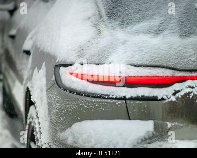 Ein Auto-Rücklicht bedeckt mit Schnee und Schmutz, Winterszene Stockfoto