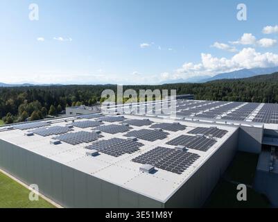 Luftaufnahmen zeigen Solarpaneele, die in einem Gebäude installiert sind und die Erzeugung erneuerbarer Energien an einem klaren Himmel hervorheben. Stockfoto