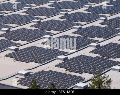 Eine Drohne erfasst auf einem Dach platzierte Solarpaneele und zeigt damit den Wandel hin zu erneuerbarer Energie und grüner Stromerzeugung. Stockfoto