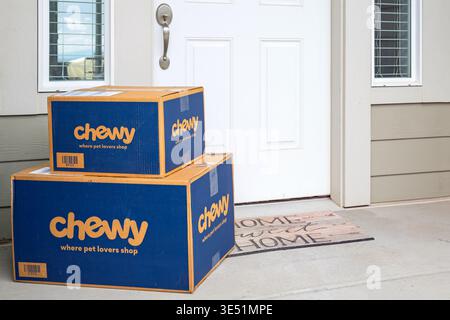 Mehrere Pakete von Chewy, dem Unternehmen, das sich auf Tierfutter und -Zubehör spezialisiert hat, sitzen vor der Haustür. Stockfoto