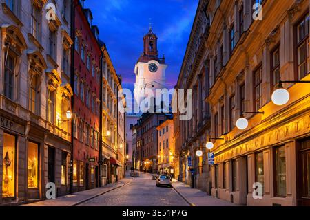 Die Storkyrkan-Kirche St. Nikolaus, die älteste Kirche in der Gamla Stan-Altstadt von Stockholm, Schweden, wird nachts durch eine Straße beleuchtet. Stockfoto