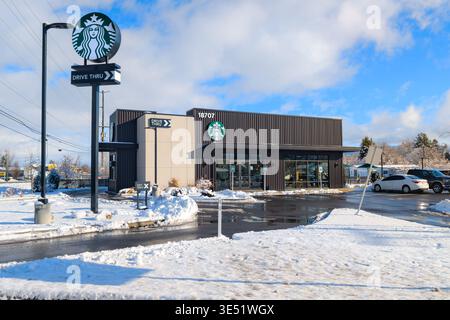 Ein eigenständiges Starbucks-Kaffeehaus mit einer Drive-Thru-Bestellstation an einem schneebedeckten Wintertag in Spokane, Washington. Stockfoto