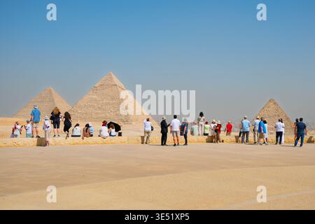 Touristen stehen an, um die Pyramiden von Gizeh zu sehen, einschließlich der Großen Pyramide Khufu, Khafre und Menkaure, mit Kairo in der Ferne, Stockfoto