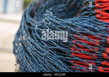 Nahaufnahme des traditionellen Fischernetzes mit blauem und rotem Seil Stockfoto