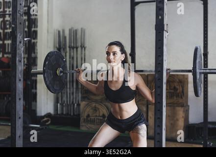 Junge Frau Trainieren mit einem barbell in einem Sport Club, hockt tun Stockfoto