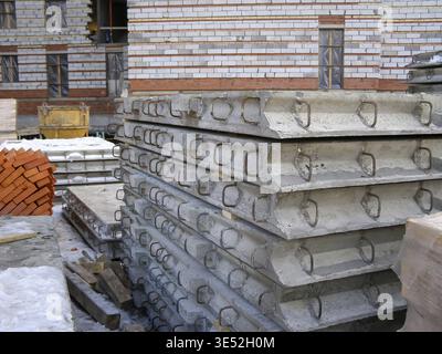 Auf einer Baustelle befindet sich ein Stapel Betonplatten mit Metallschlaufen, die für den Einsatz im Gebäude bereit sind Stockfoto