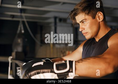 Seitenansicht eines Boxers. Junger Athlet, der sich im Ring entspannt Stockfoto