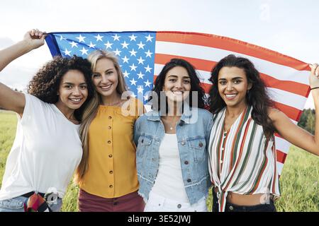 Gruppe multiethnischer Frauen mit US-Flagge. Freundinnen feiern Unabhängigkeitstag Stockfoto
