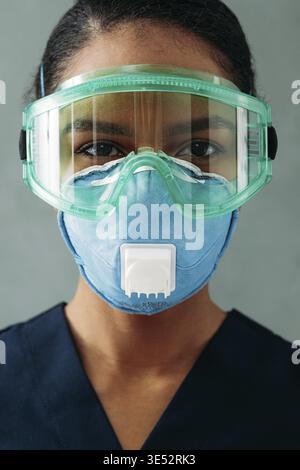 Nahaufnahme Porträt eines medizinischen Spezialisten für Atemschutzgeräte und Schutzbrille, die gerade aus der Kamera schaut Stockfoto