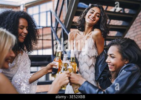 Schönen lachen Freunde Toasten mit Flaschen Bier im Freien Stockfoto
