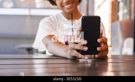 Nicht erkennbare lächelnde Frau mit Handy und unter selfie Stockfoto