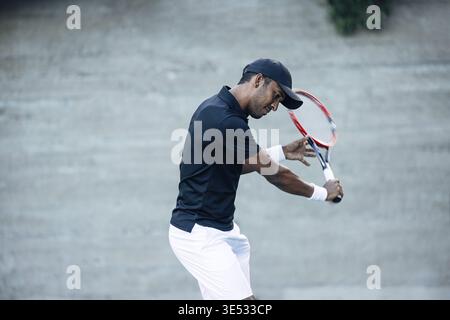 Junger Mann in Sportbekleidung mit Tennisschläger im Freien Stockfoto