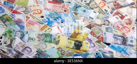Viele Banknoten unterschiedlicher Währung. Eine große Menge von zufälligen Geldrechnungen aus der Nähe. Währungsumtausch-Konzept Stockfoto