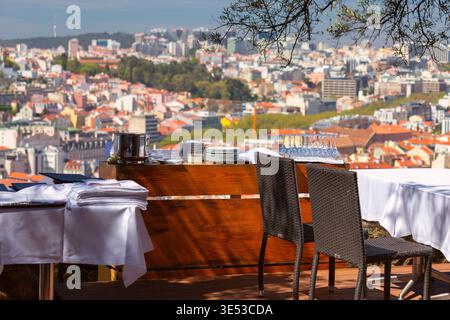 Außenterrasse des Restaurants mit Tischen und Stühlen und Blick auf die Stadt in Lissabon, Portugal Stockfoto