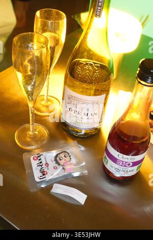 Eine Flasche Weißwein mit Gläsern, Rotweinessig und ein kleines Maskottchen auf einem Tisch Stockfoto