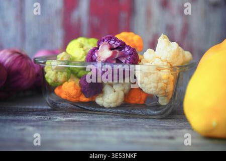 Buntes Gemüse in Glasschale auf Holztisch Stockfoto