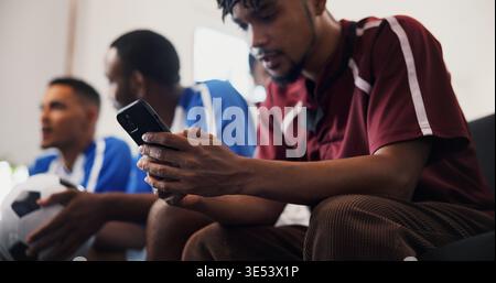 Hände, Telefon und Fernsehen mit Freunden für Fußball, Spiele und SMS mit Streaming-Service. Männer, Gruppe und Smartphone mit Scroll, Tippen und Stockfoto