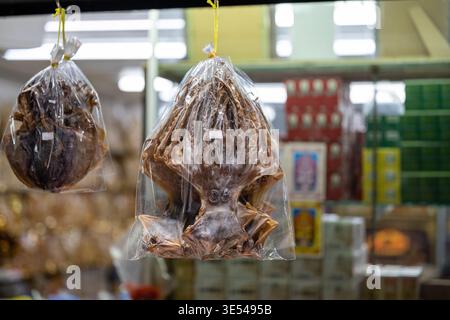 Bangkok Thailand 5. Februar 2026. Getrocknete Tintenfische in Plastiktüte, die am Essensstand auf dem Chinatown Markt hängen. Stockfoto