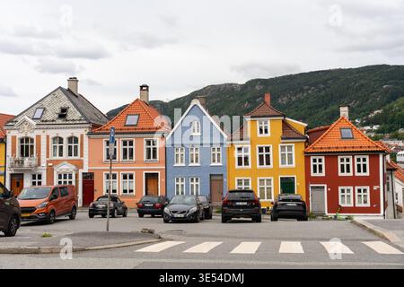 Bergen, Norwegen - 6. Juli 2024: Bunte Wohnhäuser in Bergen mit Bergen im Hintergrund. Stockfoto