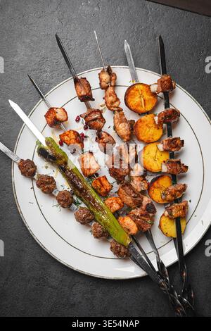 Gegrillte Fleischspieße mit Gemüse auf Teller Stockfoto