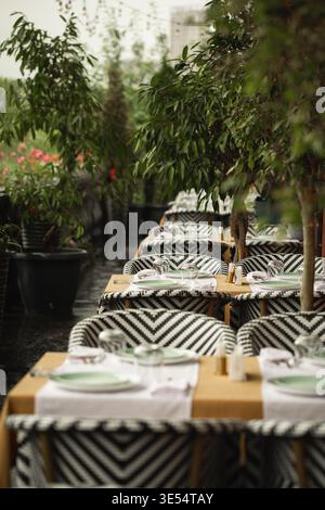 Sommerrestaurant mit Terrasse mit Tischen und Grün Stockfoto