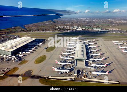 Luftaufnahme des Heathrow Terminal 5 in London mit mehreren British Airways Flugzeugen, die an den Gates geparkt sind, fotografiert von einem Flugzeug während des Starts Stockfoto