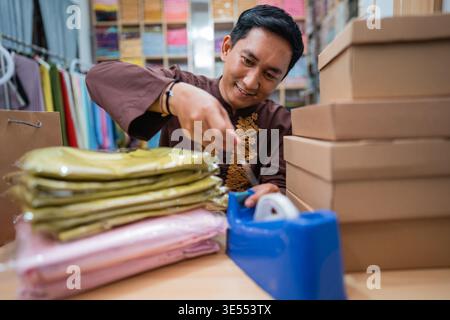 Eigentümer, der sein Produkt verpackt und für die Lieferung vorbereitet Stockfoto