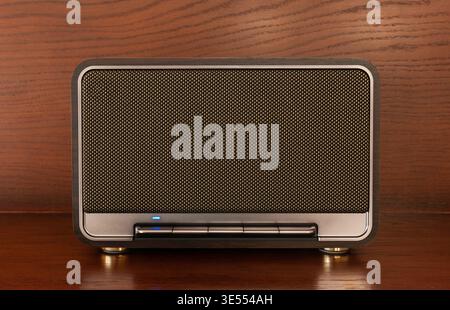 Tragbarer kabelloser Bluetooth-Lautsprecher im Retro-Stil auf Holzoberfläche Stockfoto