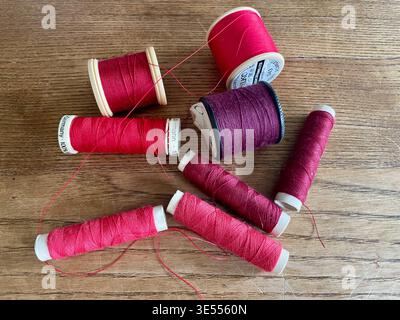 Nährollen aus Baumwolle und Polyester in roten Farbtönen england uk Stockfoto