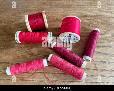 Nährollen aus Baumwolle und Polyester in roten Farbtönen england uk Stockfoto