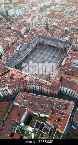 Blick aus der Vogelperspektive auf die Plaza Mayor mit ihren historischen roten Gebäuden und den umliegenden Dächern in Madrid, Gemeinde Madrid, Spanien. Stockfoto