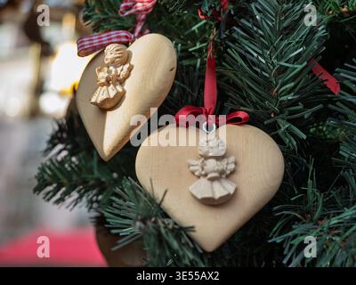Hölzerner Herzschmuck Mit Geschnitzten Engelsfiguren Auf Dem Baum. Stockfoto