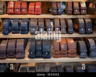 Mehrere Reihen Handgefertigter Ledergürtel Auf Holzregalen. Stockfoto