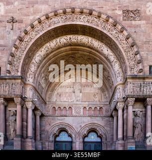 Reich verziertes romanisches Kirchenportal mit Steinbogen, Säulen, Reliefskulpturen und Doppelbogentüren, detaillierte historische Architekturfassade Stockfoto
