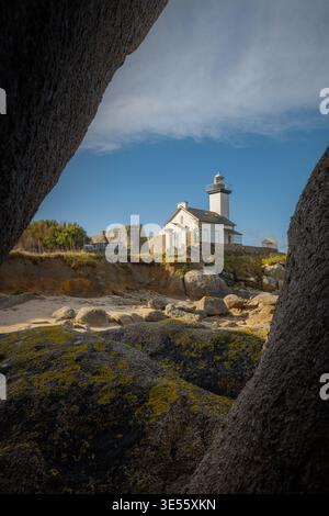 Blick auf den Leuchtturm Phare de Pontusval, der von großen Granitblöcken eingerahmt wird, an der felsigen Küste von Plouneour-Brignogan-plages, Bretagne, Frankreich. Stockfoto