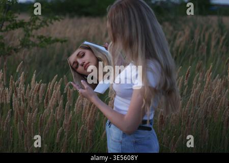 Frau, die Spiegel im Feld hält Stockfoto